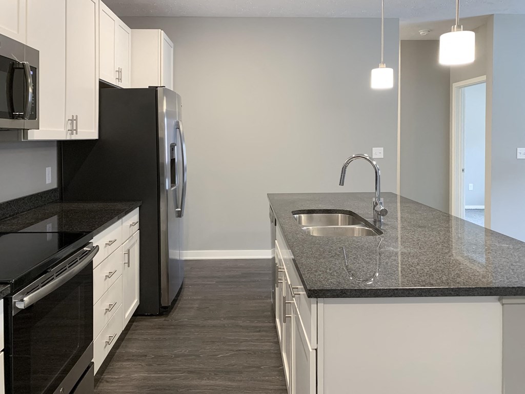 Kitchen with white cabinets and dark granite counters The Flats at Shadow Creek in Lincoln Nebraska