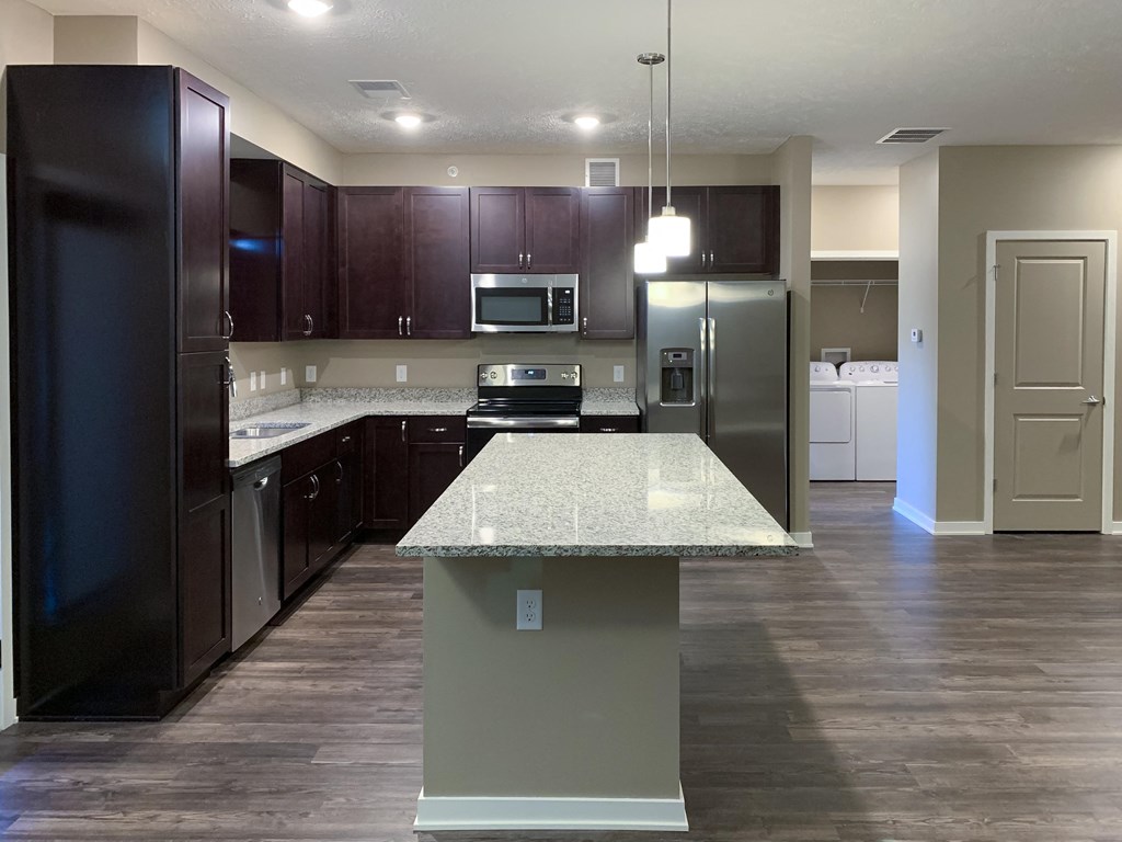 Kitchen with dark brown cabinets and large kitchen island and matching stainless steel  appliances