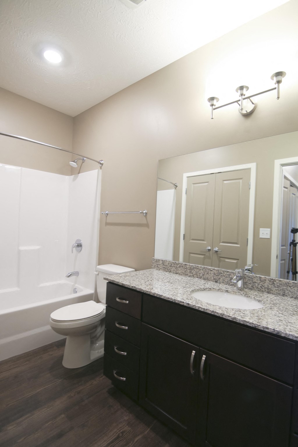 Bathroom with dark brown vanity and large mirror