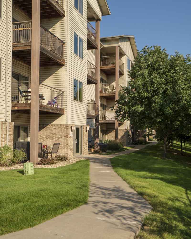 Flats-style apartments with balconies overlooking Zorinsky Lake Park at Grand Legacy apartments and townhomes in west Omaha NE 68130