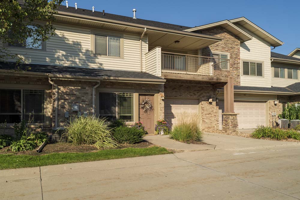 Townhome-style villas with attached garages and large balconies  at Grand Legacy apartments and townhomes in west Omaha NE 68130