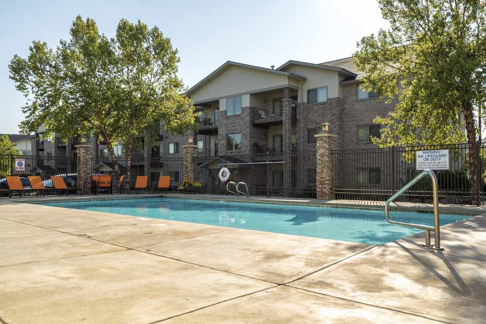 Swimming pool with lounge seating  at Grand Legacy apartments and townhomes in west Omaha NE 68130