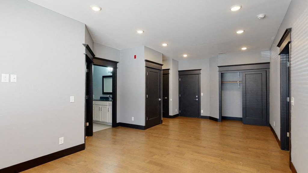 Living room with light gray walls, black trim, and wooden floors