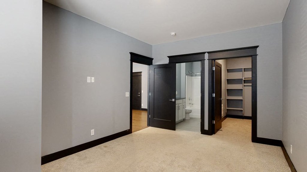 master bedroom with a walk in closet and a bathroom