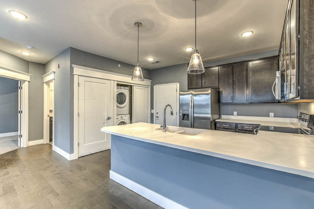 Large kitchen with plenty of counter space, including a washer and dryer in unit at The Helen