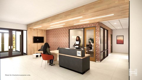 A woman sits at a reception desk in a modern office.