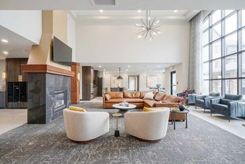 The clubhouse lounge featuring a floor to ceiling window, lounge seating, and a community TV