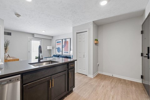 A kitchen with dark wood cabinets and a stainless steel sink.