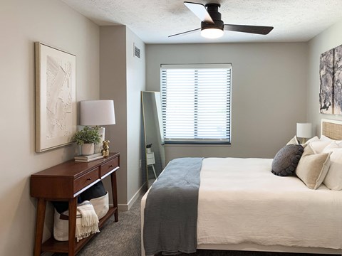 a bedroom with a ceiling fan and a window