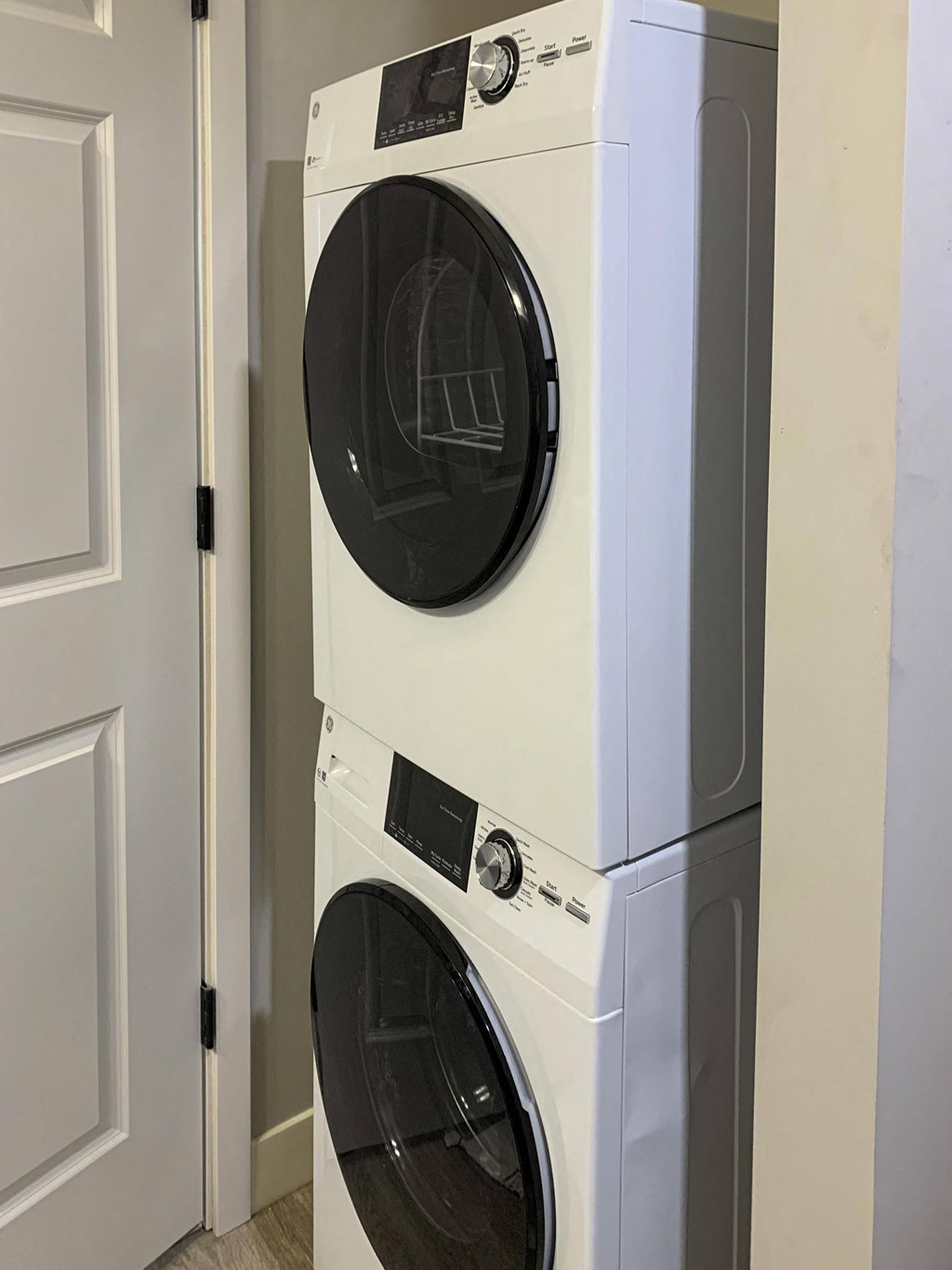 a front load stacked washer and dryer in a laundry room