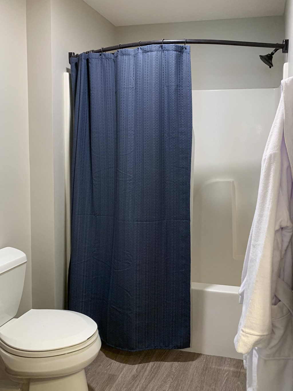 a small bathroom with a white toilet and a blue shower curtain