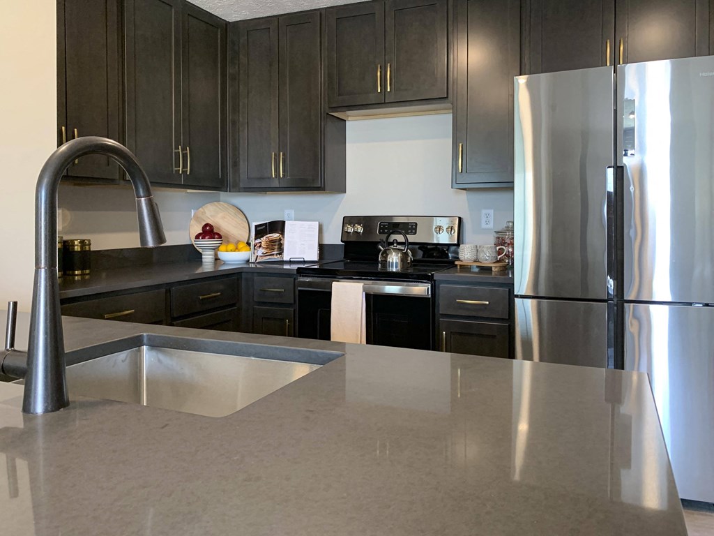 a kitchen with dark cabinets and a large island