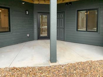 dark gray exterior of building with concrete patio