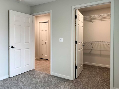 a bedroom with a closet and a door open to a closet