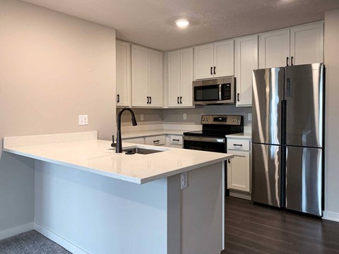 a kitchen with white finishes and stainless steel appliances