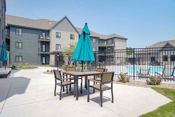 a courtyard space with a table and chairs and umbrella