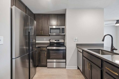 A modern kitchen with stainless steel appliances and dark wood cabinets.