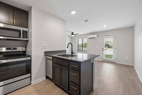A modern kitchen with dark wood cabinets and stainless steel appliances.