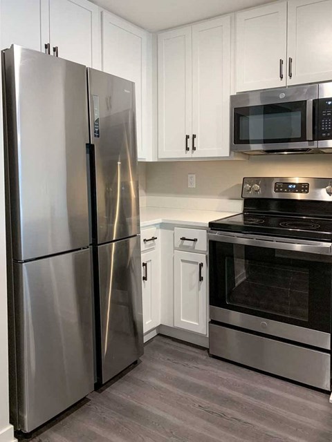a modern kitchen with a stainless steel refrigerator and oven