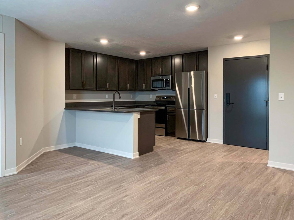 kitchen with a stainless steel fridge and dark cabinets