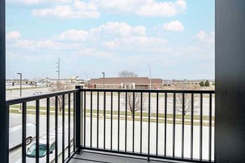 a balcony with a view of a parking lot and a building