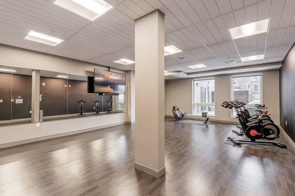 Spin and yoga studio with TV screen for on-demand fitness classes