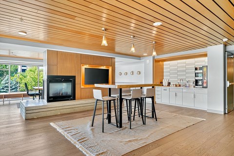 A modern living room with a wooden ceiling and a television on the wall.