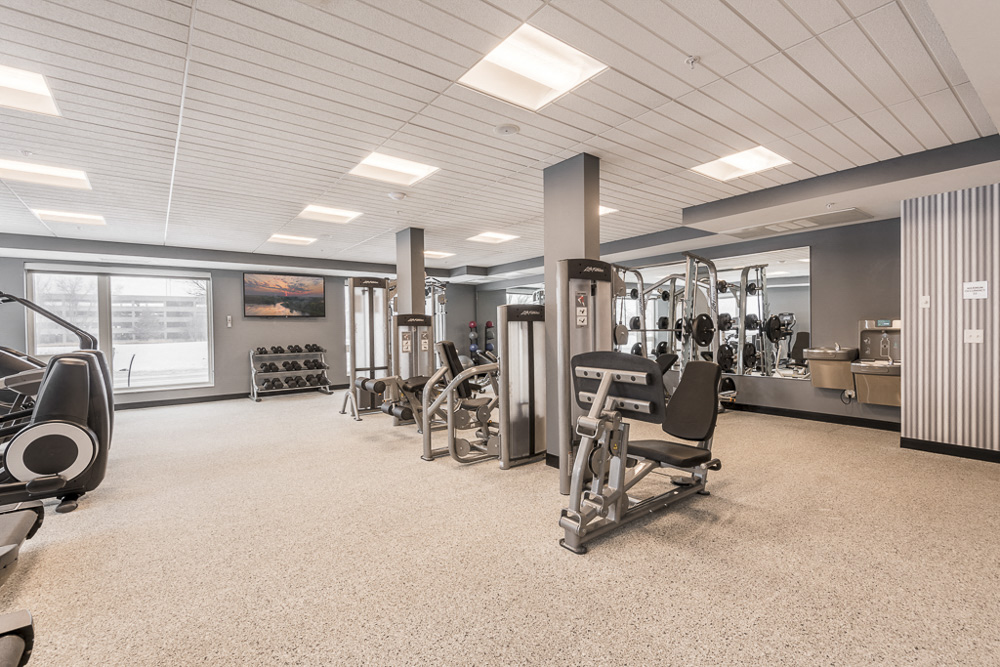 View of expansive gym with weightlifting machines at The Preserve apartments in Bloomington