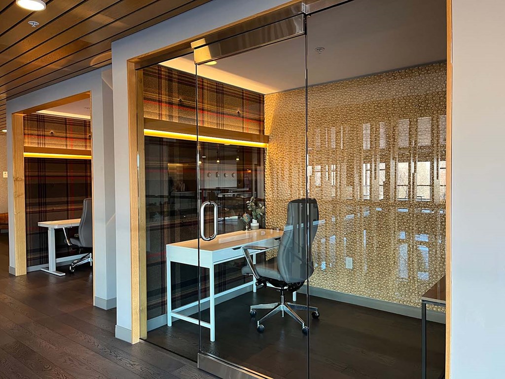 a work-from-home suite with a glass door, desk, and office chair