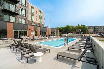 Resort style swimming pool with sun tanning loungers at The Rowan apartments in Eagan, MN