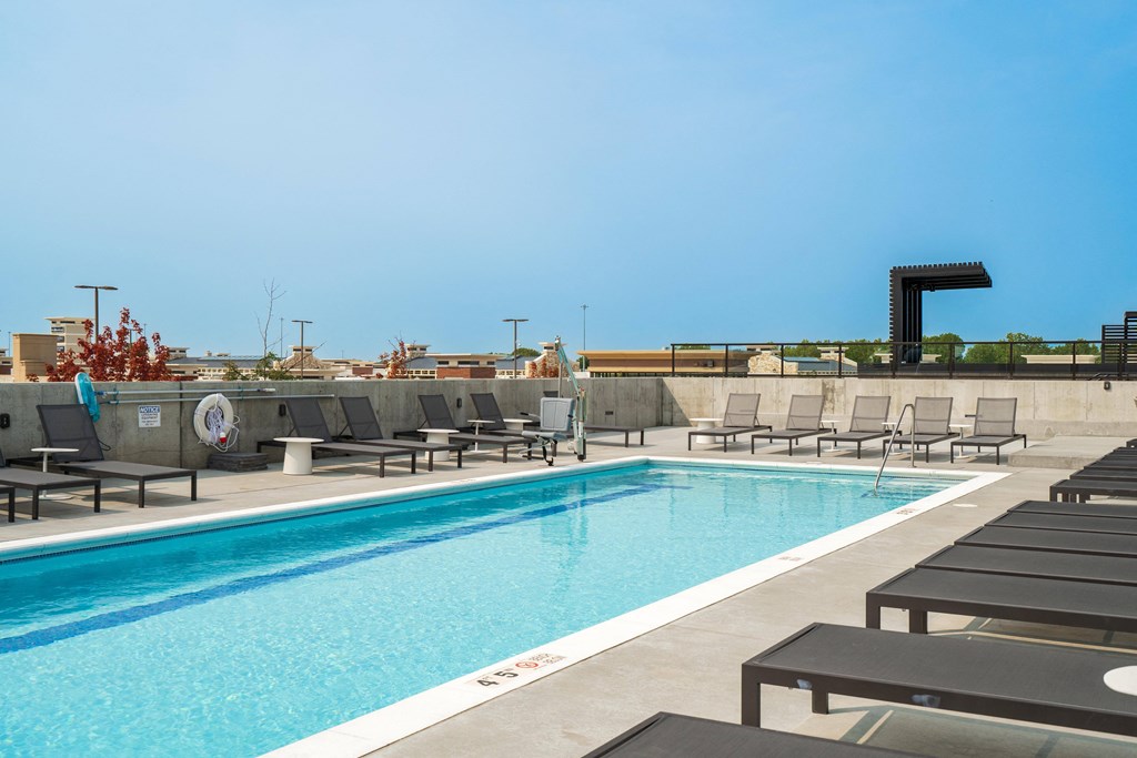 Resort style swimming pool with sun tanning loungers at The Rowan apartments in Eagan, MN