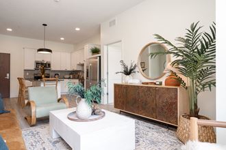 Furnished living room with large white coffee table decorated with plants and greenery - Photo Gallery