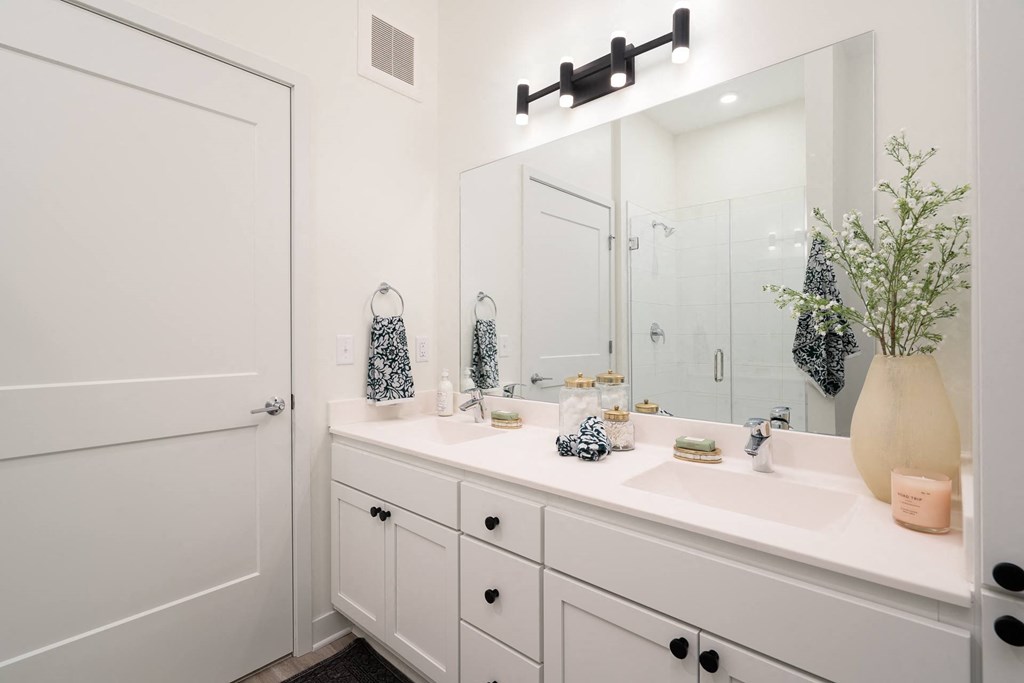 White bathroom vanity with large mirror and towel hanging on rack