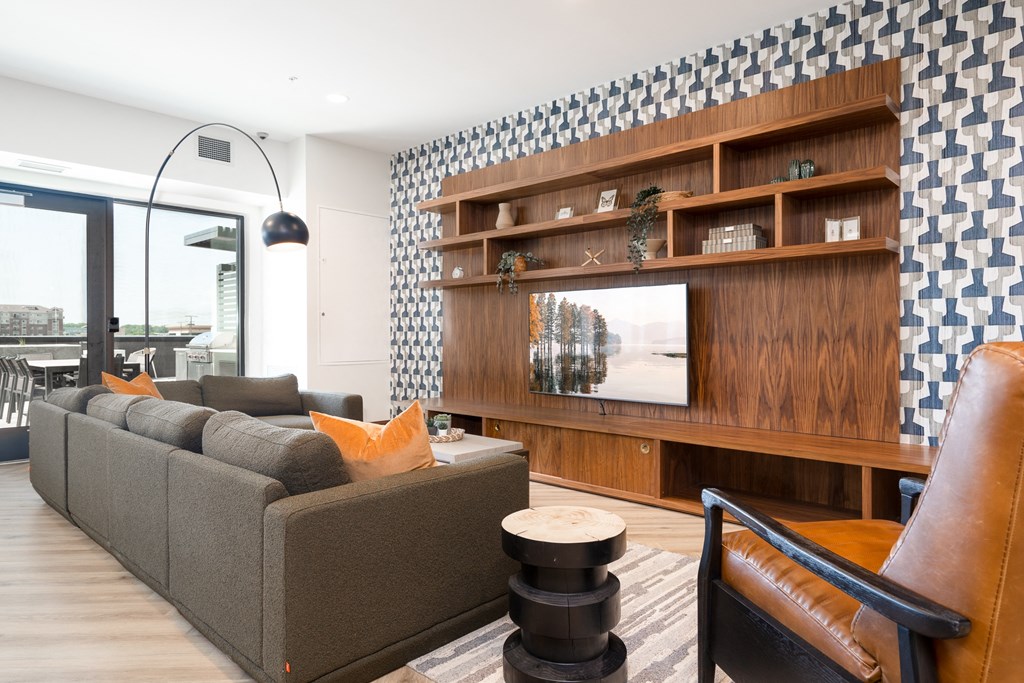 Community space television lounge with grey couch and yellow accent pillows