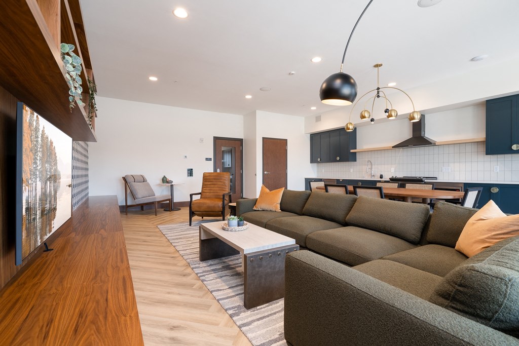 community space television lounge with grey sectional couch and yellow accent pillows.