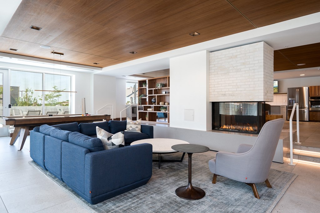 entertainment suite with couch seating and a cozy fireplace. Pool table behind the couch.