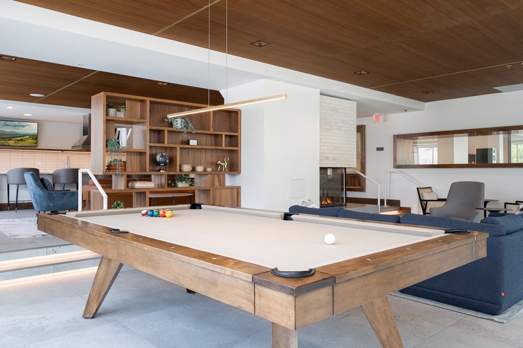 Entertainment suite pool table with couch seating behind the table.