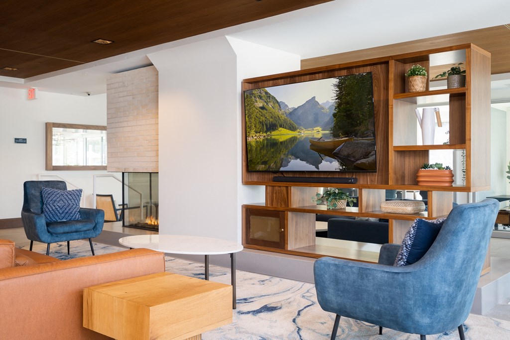 television lounge in the entertainment suite with blue chairs for seating.