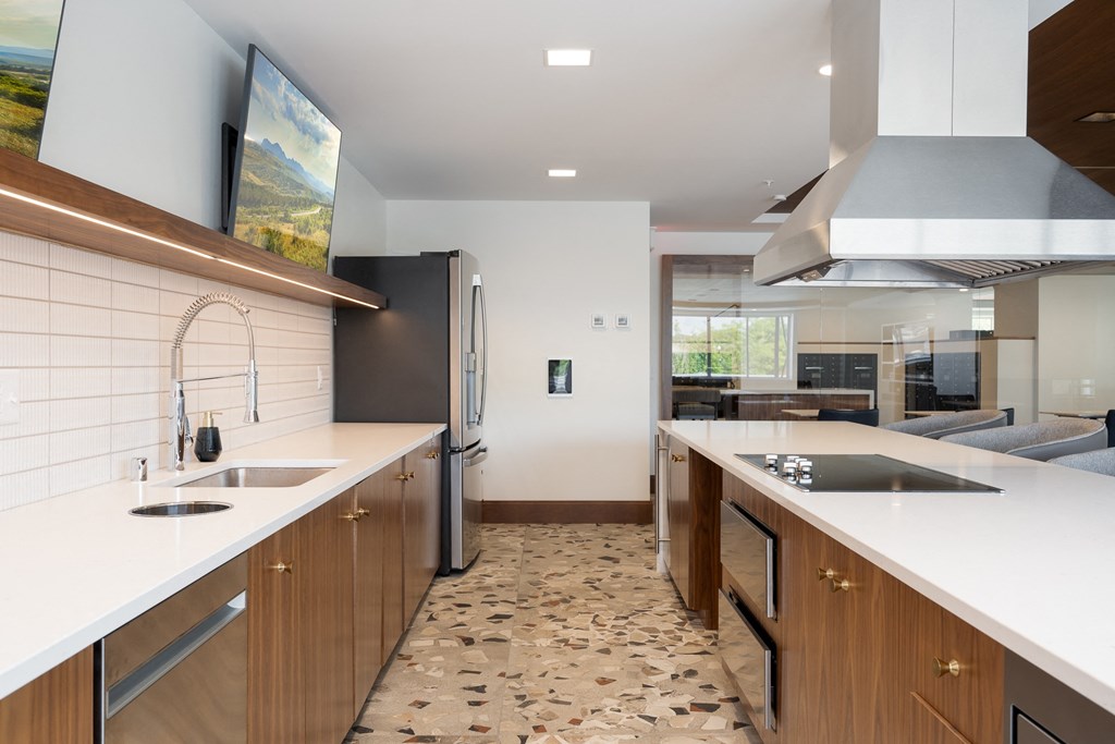 Community kitchen with dishwasher, stove, oven, sink, fridge, and television for entertainment.