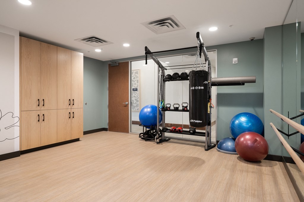 Yoga and spin studio with exercise balls, dumbbells, kettle balls, and storage in the back of the room.