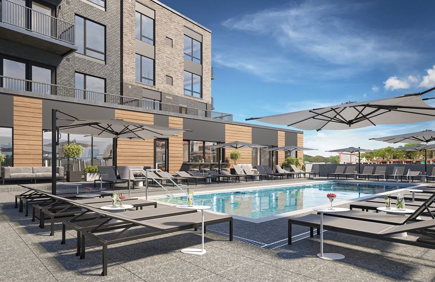 luxury resort style swimming pool with sun tanning lounge chairs at The Rowan apartments in Eagan Minnesota - Photo Gallery 1