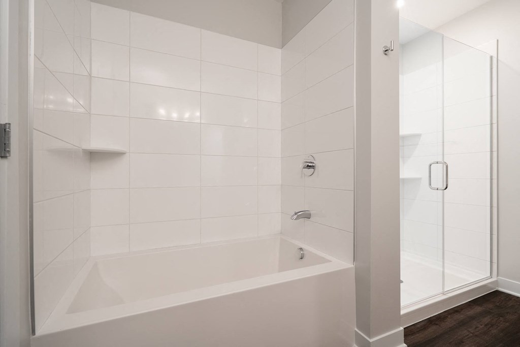 Bathroom with bath tub and walk in glass shower to the right
