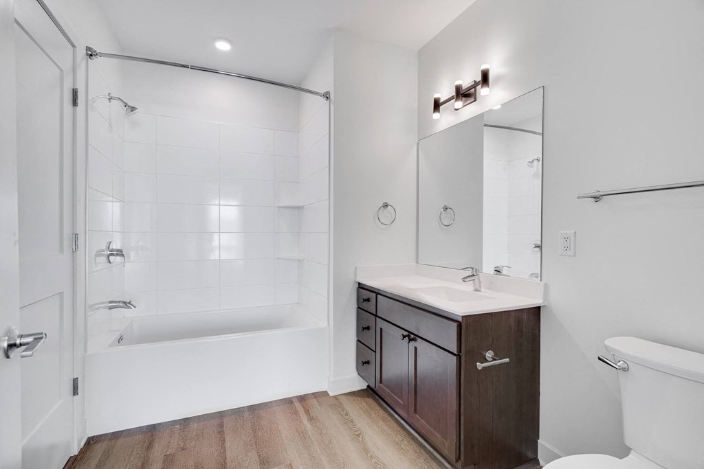 Bathroom with dark brown vanity and linen cabinet for storage and large mirror at The Rowan in Eagan Minnesota