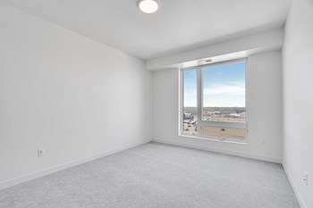 TheRowanLuxuryApartments Spacious carpeted bedroom with large window allowing a lot of natural light in at The Rowan apartments in Eagan Minnesota - Photo Gallery 5