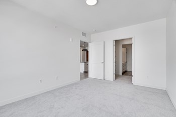 TheRowanLuxuryApartments Spacious white carpeted bedroom with walk in closet and access to bathroom at The Rowan in Eagan Minnesota - Photo Gallery 3