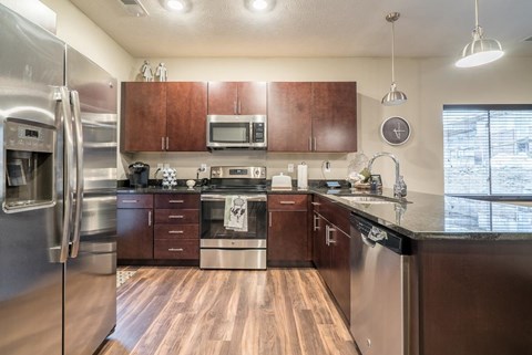 A kitchen with wooden floors and stainless steel appliances.
