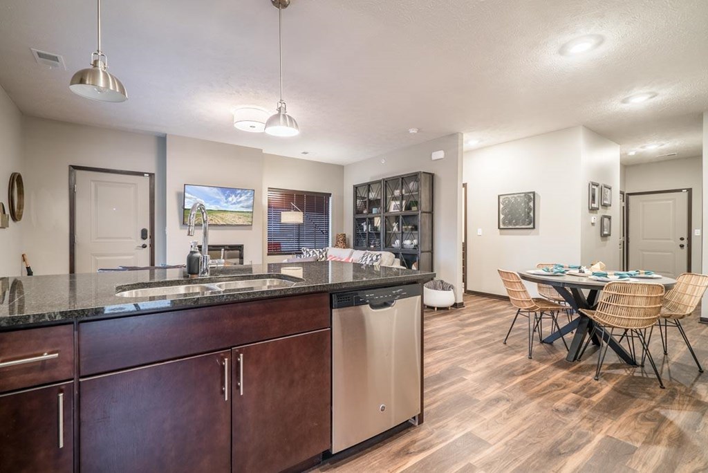 A kitchen with dark wood cabinets and a black countertop.