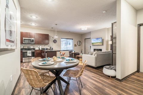A modern kitchen with a dining table set for two.