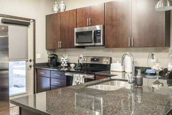 Interiors-Kitchen with dark cabinetry, modern hardware and granite countertops