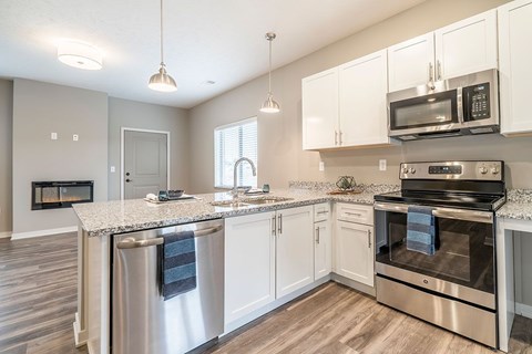Apartment kitchen with white cabinets and stainless steel appliances